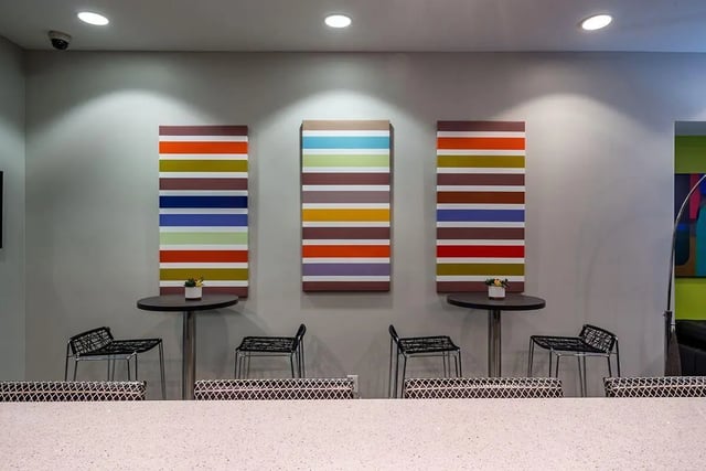 Colorful art three tables chairs lounge area at The Avenue Indianapolis in Indianapolis Student Accommodation