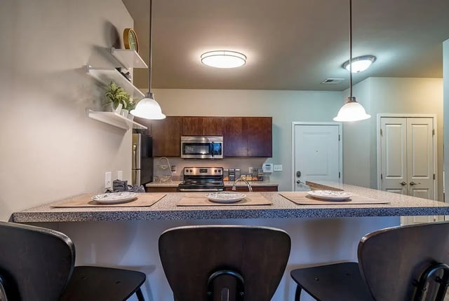 Bar with plates and stools kitchen at The Avenue Indianapolis in Indianapolis Student Accommodation