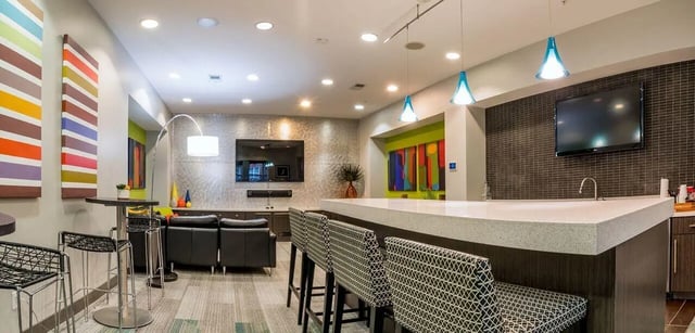 Modern lounge area with bar, seating, and television. at The Avenue Indianapolis in Indianapolis Student Accommodation