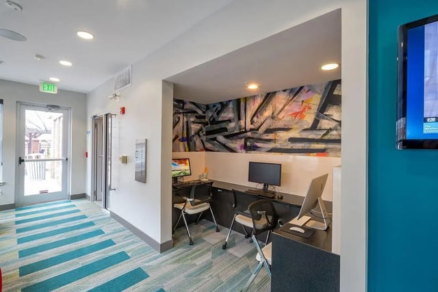 Computers and chairs in study area with abstract mural Image Type Study Area at The Avenue Indianapolis in Indianapolis Student Accommodation