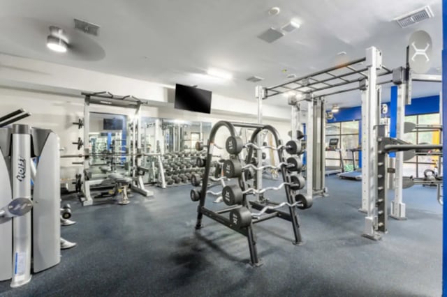 Gym equipment dumbbells barbells treadmills fitness room at Lark Central Florida in Orlando Student Accommodation