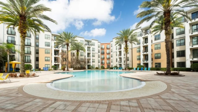 Resort style pool surrounded by palm trees exterior at Lark Central Florida in Orlando Student Accommodation