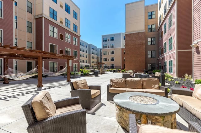 Outdoor seating area with hammocks and fire pit courtyard at BlockONE in Ames Student Accommodation