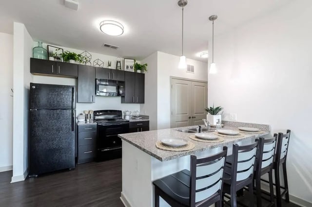 Black appliances counter with barstools kitchen at BlockONE in Ames Student Accommodation