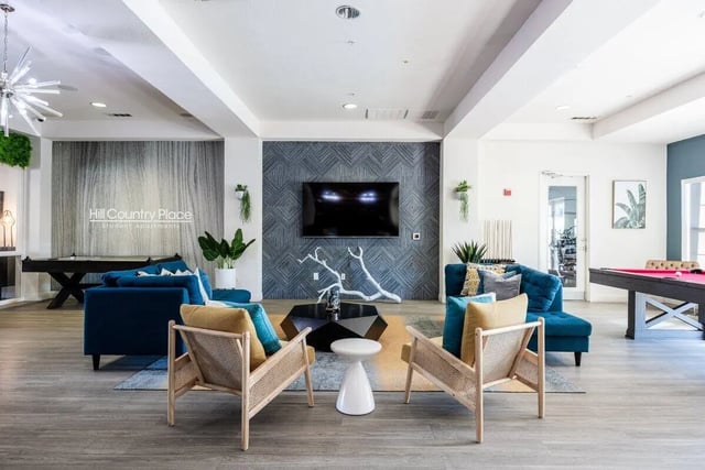 Blue sofas pool table and seating living room at Hill Country Place in San Antonio Student Accommodation