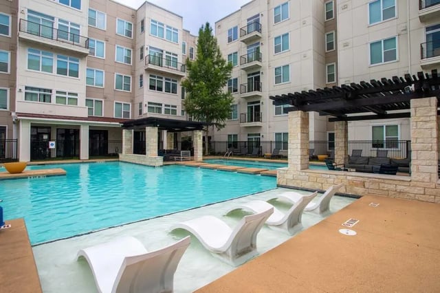 Modern building with pool and white loungers exterior at Northpoint Crossing in College Station Student Accommodation