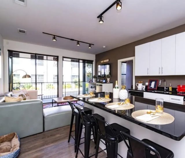 Bar stools and counter with living area Living room kitchen at Lark Oxford in Oxford Student Accommodation