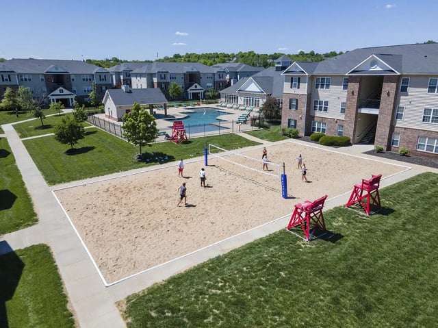 Volleyball court with people and buildings exterior at Helix 24 in Lawrence Student Accommodation