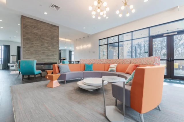 Orange grey sectional sofa modern fireplace lounge area at Lark Syracuse in Syracuse Student Accommodation