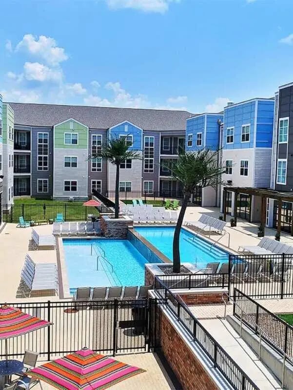 Apartment complex pool lounge chairs umbrellas exterior at Lark Tuscaloosa in Tuscaloosa Student Accommodation