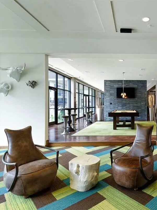 Brown leather chairs and wood stump living room at Lark Tuscaloosa in Tuscaloosa Student Accommodation