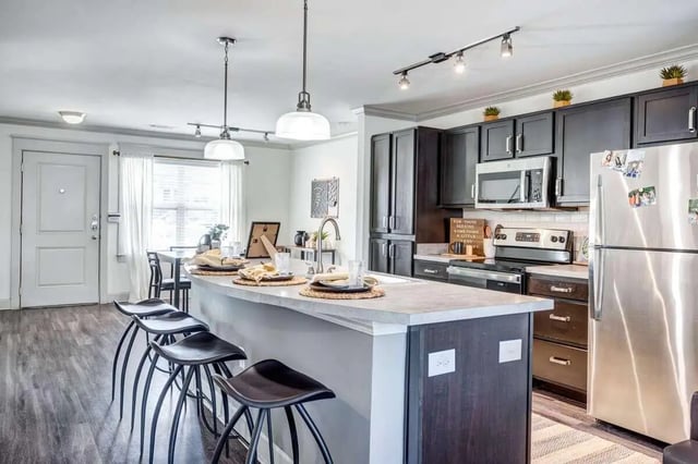 Kitchen island with stools dark cabinets refrigerator stove kitchen at Redpoint San Marcos in San Marcos Student Accommodation