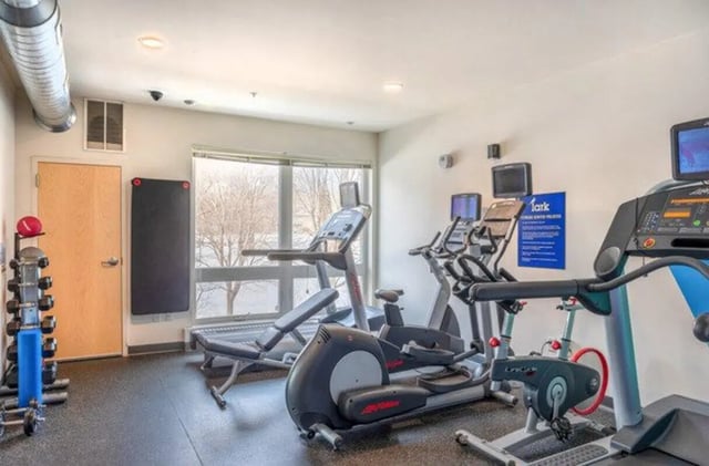 Dumbbells treadmills elliptical bikes gym Fitness Area at Lark at Randall in Madison Student Accommodation