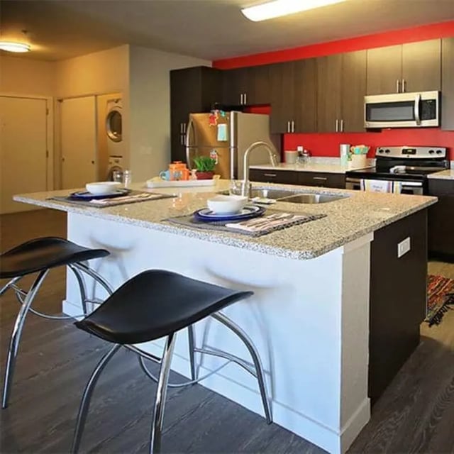Island with bar stools stainless steel appliances kitchen at Lark in the Woods in Tuscaloosa Student Accommodation