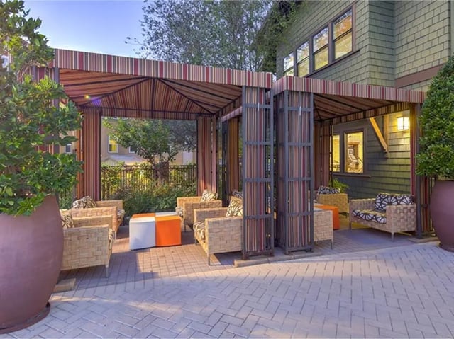 Wicker seating striped awnings and orange tables outdoor living space at Camino del Sol in Irvine Student Accommodation