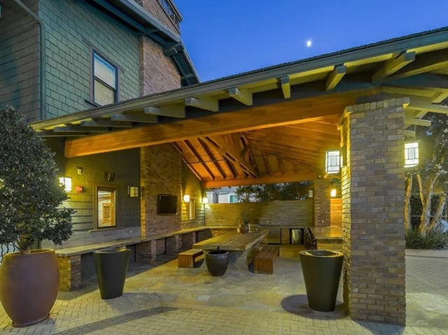 Covered outdoor seating area with tables and benches patio at Camino del Sol in Irvine Student Accommodation