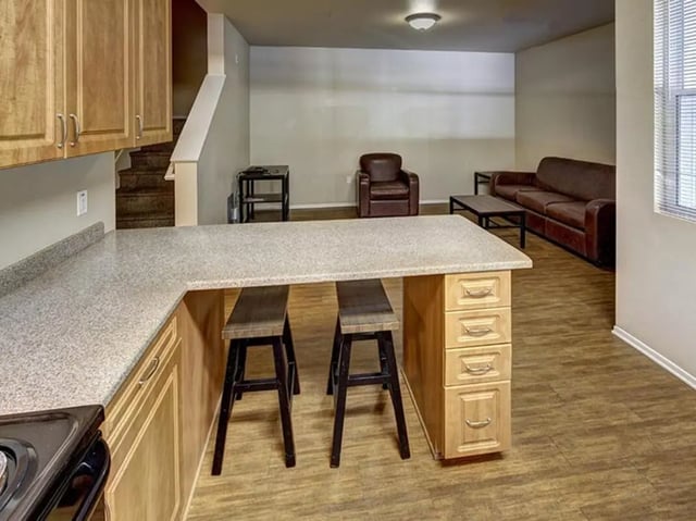 Kitchen island with stools and living room furniture living room at Camino del Sol in Irvine Student Accommodation