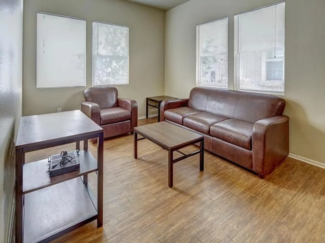 Brown leather sofa armchair coffee table living room at Camino del Sol in Irvine Student Accommodation