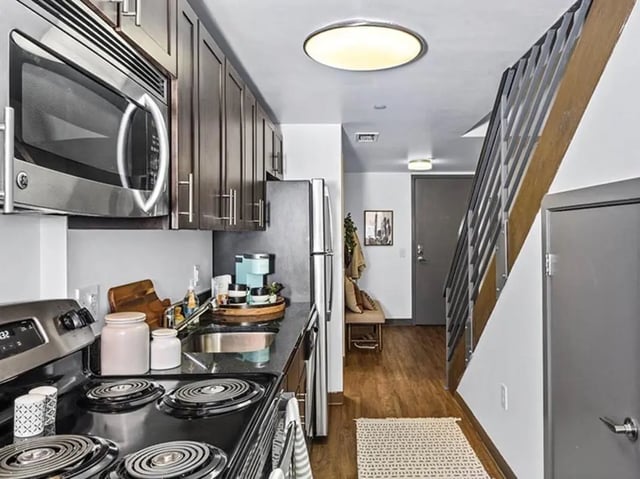 Kitchen with stove microwave cabinets and stairs. at Chestnut Square in Philadelphia Student Accommodation