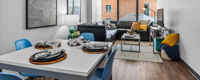 Dining table with blue chairs and sectional living room at Chestnut Square in Philadelphia Student Accommodation