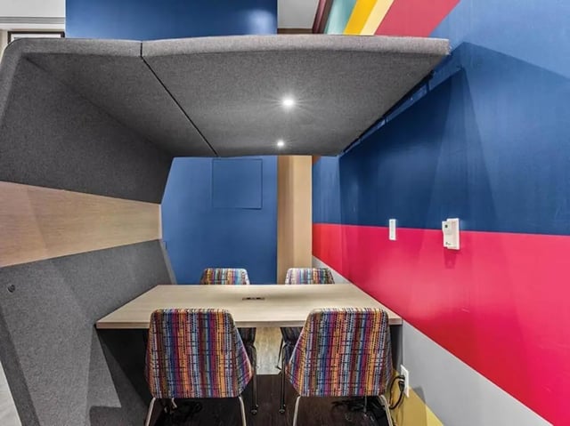 Study pod with table chairs and colorful walls Study area at Chestnut Square in Philadelphia Student Accommodation