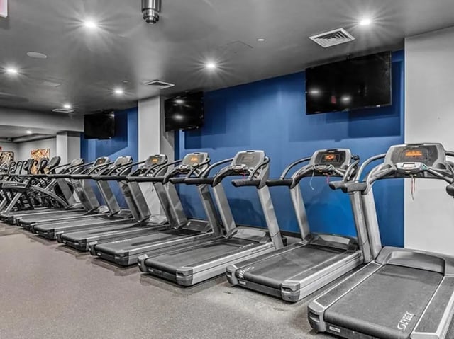 Row of treadmills with screens gym at Chestnut Square in Philadelphia Student Accommodation