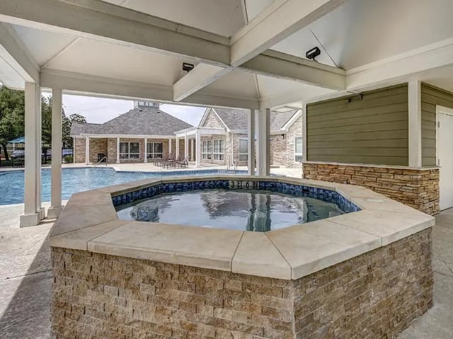 Octagonal spa with tiled interior and stone exterior pool area at Aggie Station in Bryan Student Accommodation