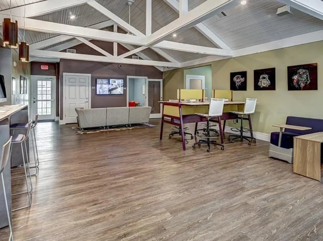 Study tables couch bar stools and artwork common area at Aggie Station in Bryan Student Accommodation
