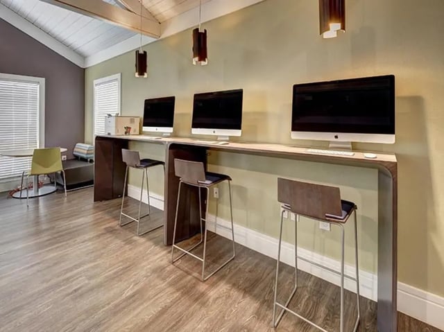 Computers and bar stools at counter study area at Aggie Station in Bryan Student Accommodation