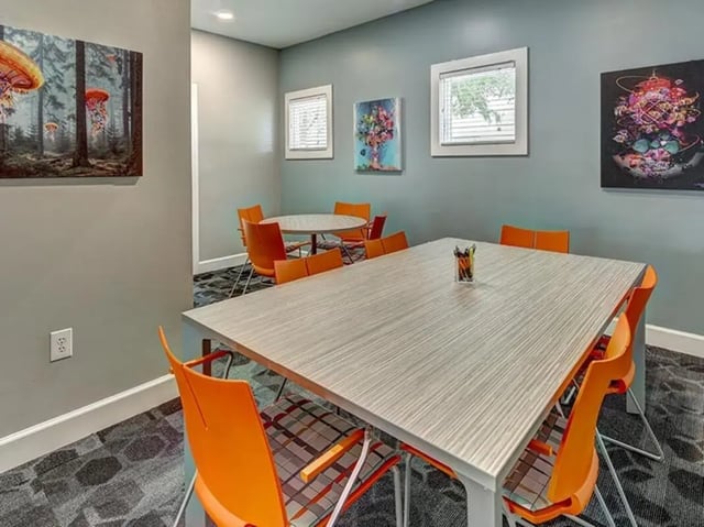 Rectangular table orange chairs study room at Aggie Station in Bryan Student Accommodation