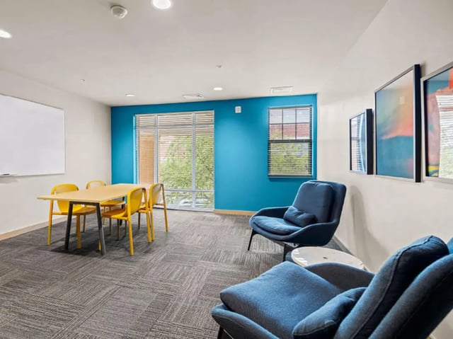 Table chairs whiteboard artwork blue chairs lounge at 1200 West Marshall in Richmond Student Accommodation