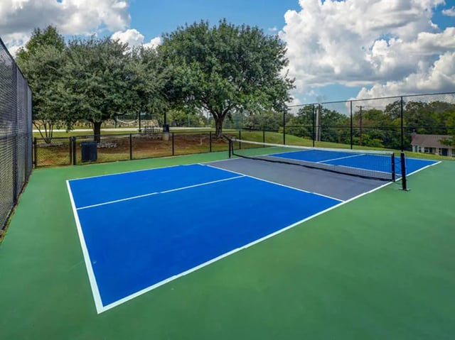 Blue and grey pickleball court with nets outdoors playing area at City Parc at Fry Street in Denton Student Accommodation
