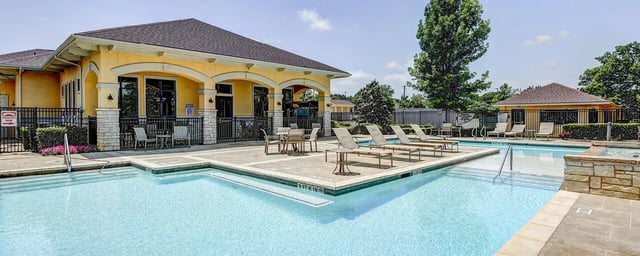 Loungers tables near pool building exterior at City Parc at Fry Street in Denton Student Accommodation