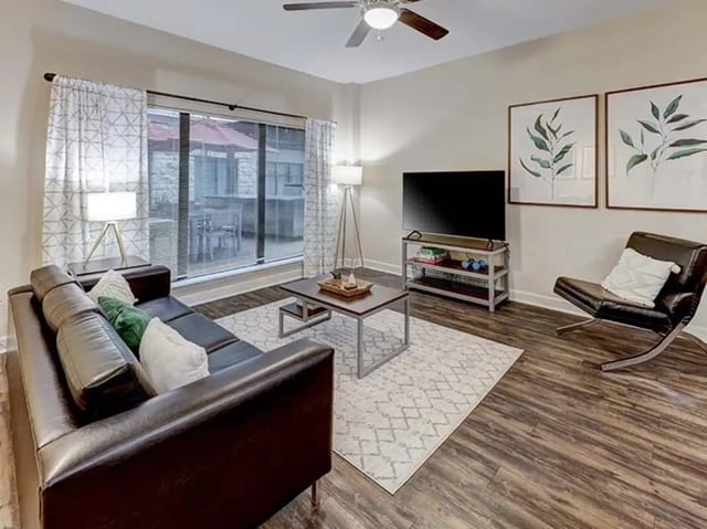 Leather sofa coffee table television and chair living room at Crest at Pearl in Austin Student Accommodation