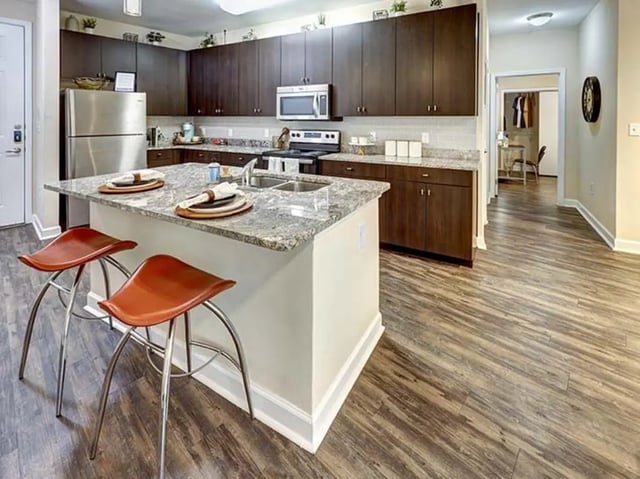Kitchen island with stools stainless steel refrigerator kitchen kitchen at Crest at Pearl in Austin Student Accommodation