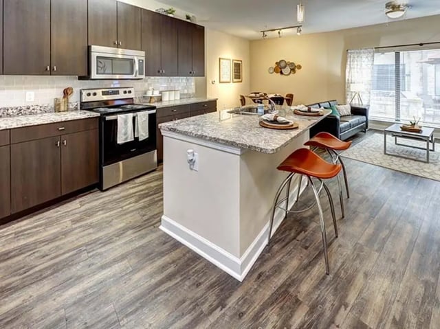 Modern kitchen with island bar and living area Kitchen at Crest at Pearl in Austin Student Accommodation