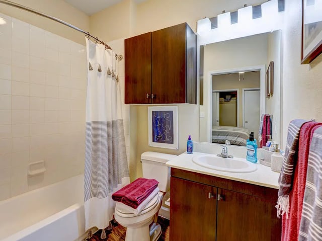 White tub shower toilet dark cabinets sink bathroom at Crest at Pearl in Austin Student Accommodation