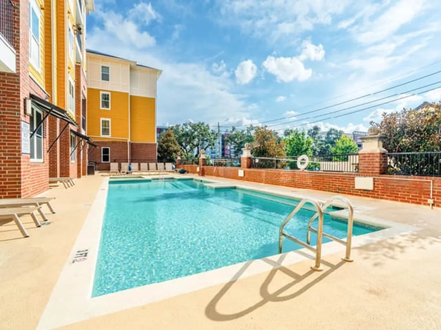 Swimming pool with lounge chairs and ladder exterior at 601 Copeland in Tallahassee Student Accommodation
