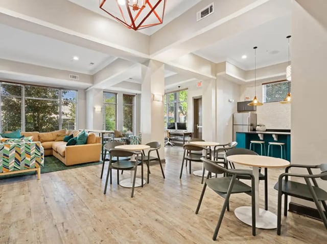Lounge with sectional couch tables chairs kitchen living room at 601 Copeland in Tallahassee Student Accommodation