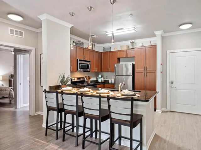 Kitchen island with four stools wooden cabinets and stainless steel appliances kitchen at 601 Copeland in Tallahassee Student Accommodation