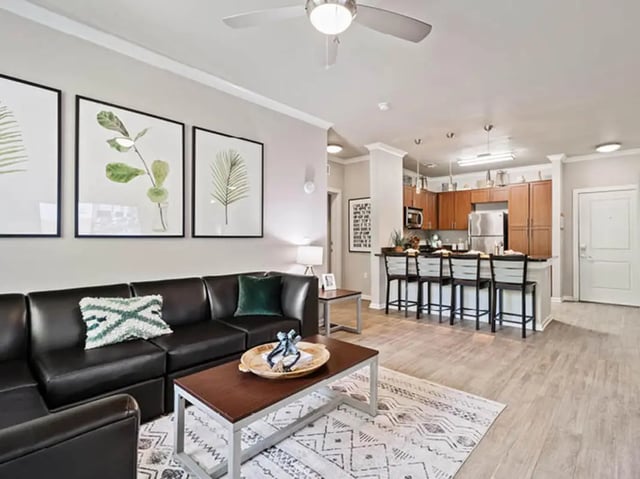 Black sectional sofa artworks kitchen bar stools living room at 601 Copeland in Tallahassee Student Accommodation