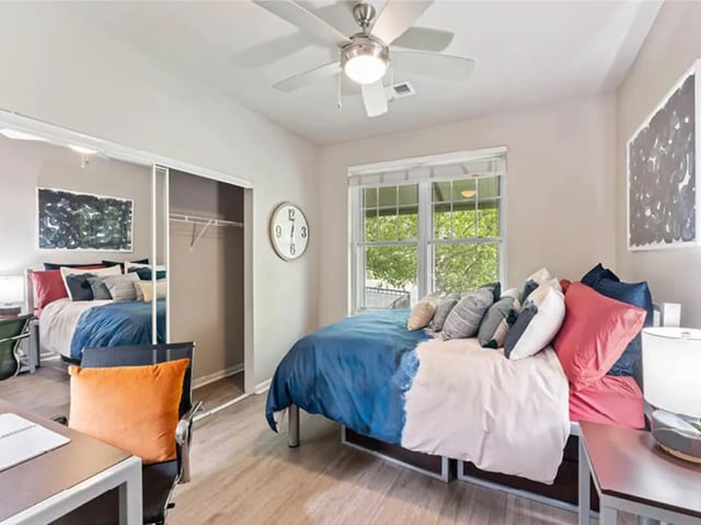 Two beds with colorful pillows a desk and closet bedroom at 601 Copeland in Tallahassee Student Accommodation