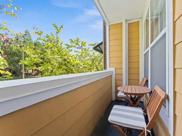 Wooden chairs and table on balcony exterior at 601 Copeland in Tallahassee Student Accommodation