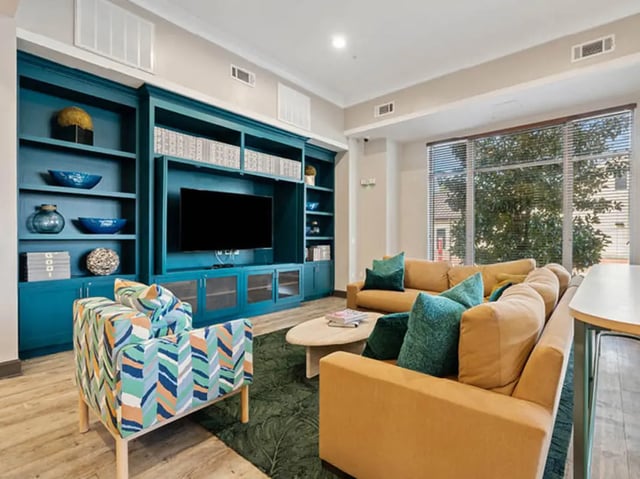 Teal shelves couch chair patterned sofa living room at 601 Copeland in Tallahassee Student Accommodation