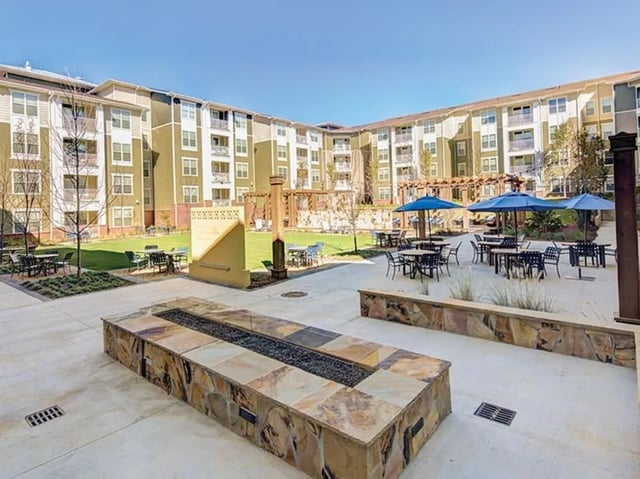 Courtyard with tables umbrellas and fire pit exterior at 160 Ross in Auburn Student Accommodation
