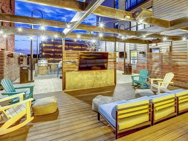 Outdoor lounge with seating and TV playing area at Campus Edge on Pierce in West Lafayette Student Accommodation