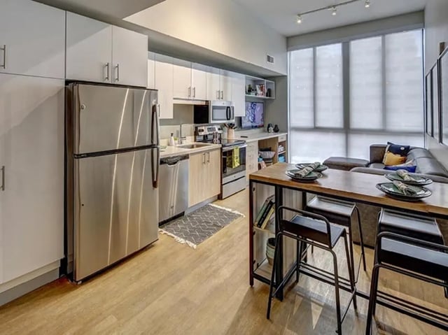 Kitchen and living area with sofa dining table at Campus Edge on Pierce in West Lafayette Student Accommodation