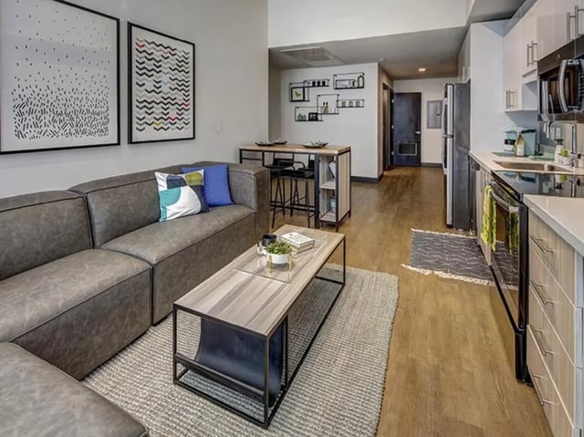 Grey sofa coffee table bar kitchen living room at Campus Edge on Pierce in West Lafayette Student Accommodation