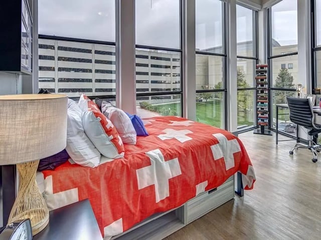 Bed with red swiss cross duvet and pillows study area bedroom at Campus Edge on Pierce in West Lafayette Student Accommodation