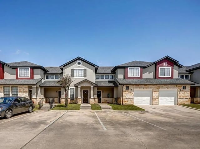 Apartment complex exterior with car and garages exterior at Bishops Square in San Marcos Student Accommodation